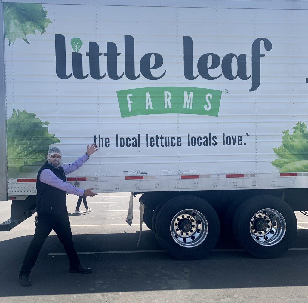 Feeding PA CEO, CFO Shea Saman poses with a Little Leaf Farms Tractor Trailer at the McAdoo, PA Greenhouse Grand Opening. 
